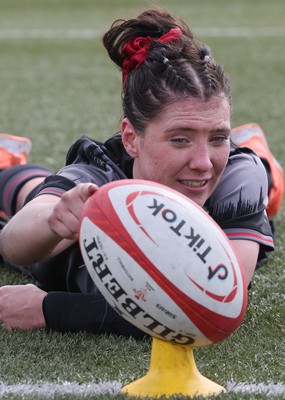 210323 - Wales Women Rugby Training Session - Georgia Evans helps Keira Bevan by steadying the ball during a training session ahead of Wales’ opening Women’s 6 Nations match against Ireland