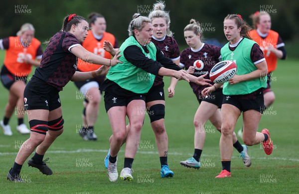 230424 - Wales Women Rugby Training - Hannah Bluck offloads with Lisa Neumann in support during training ahead of Wales’ Guinness Women’s 6 Nations match against Italy