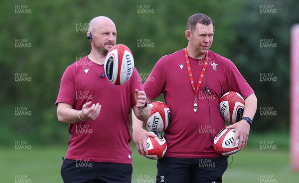 230424 - Wales Women Rugby Training - Mike Hill, Wales Women forwards coach, left and Ioan Cunningham, Wales Women head coach, during training ahead of Wales’ Guinness Women’s 6 Nations match against Italy