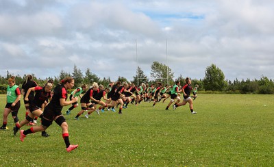 230822 - Wales Women rugby squad players warm up during a training session against the Canadian Women’s rugby squad near Halifax