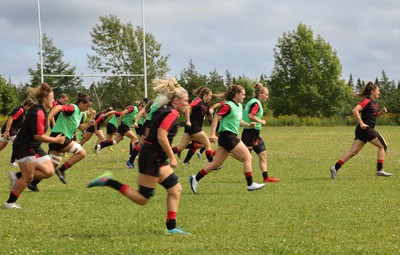 230822 - Wales Women rugby squad players warm up during a training session against the Canadian Women’s rugby squad near Halifax