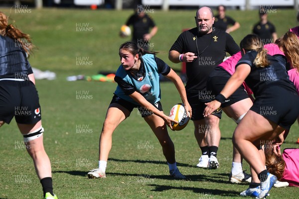 240725 - Wales Women Rugby Training at The Southport School, Southport - Nel Metcalfe is watched by Sean Lynn, Wales Women head coach during a Wales Womens Rugby training session ahead of their first tour match against Australia