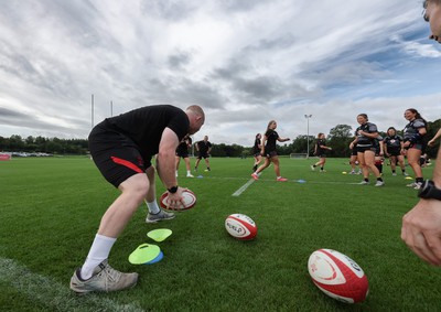 240823 - Wales Women Training session - Jamie Cox feeds the ball to the players during training session