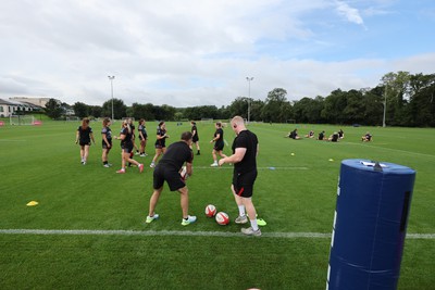 240823 - Wales Women Training session - Jamie Cox feeds the ball to the players during training session