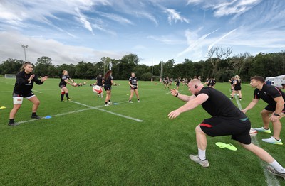 240823 - Wales Women Training session - Jamie Cox feeds the ball to the players during training session