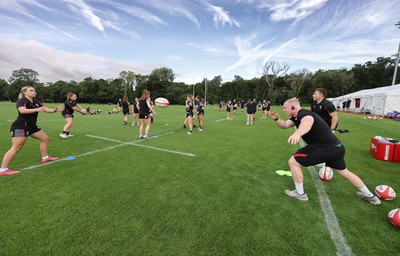 240823 - Wales Women Training session - Jamie Cox feeds the ball to the players during training session