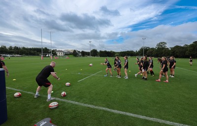 240823 - Wales Women Training session - Jamie Cox feeds the ball to the players during training session