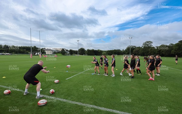 240823 - Wales Women Training session - Jamie Cox feeds the ball to the players during training session