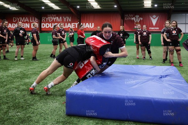 250324 - Wales Women Rugby Training Session  - Nel Metcalfe is tackled during training session ahead of the Guinness Women’s 6 Nations match against England
