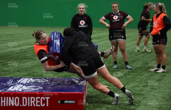 250324 - Wales Women Rugby Training Session  - Carys Cox is tackled during training session ahead of the Guinness Women’s 6 Nations match against England