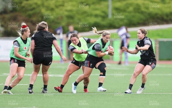 260923 - Wales Women Rugby Training Session - Kerin Lake takes on Cana Williams and Kat Evans during a training session at Stadium CSM, north Wales