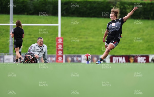 260923 - Wales Women Rugby Training Session - Robyn Wilkins kicks as Shaun Connor looks on during a training session at Stadium CSM, north Wales