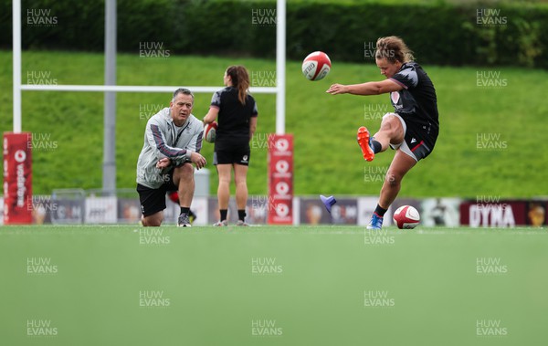 260923 - Wales Women Rugby Training Session - Robyn Wilkins kicks as Shaun Connor looks on during a training session at Stadium CSM, north Wales