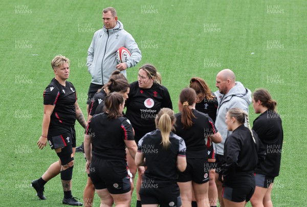 280923 - Wales Women Rugby Training Session - Coach Mike Hill works with the forwards as Ioan Cunningham looks on during a training session ahead of the match against USA at Stadium CSM