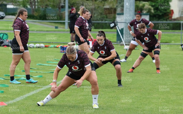 301023 - Wales Women Rugby Training Session - Kelsey Jones, Bryonie King, Kate Williams and Sisilia Tuipulotu stretch out during a training session at Pakuranga United RFC ahead of their WXV1 match against Australia