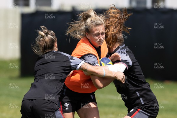 271022 - Wales Women Rugby Training Session - Hannah Jones of Wales is stopped by Keira Bevan and Niamh Terry of during a training session ahead of the Women’s Rugby World Cup Quarter Final against New Zealand