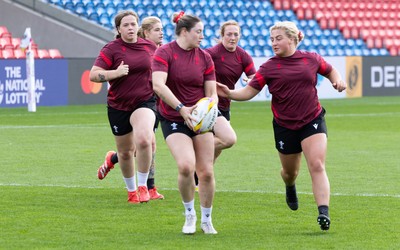 290825 - Wales Women Rugby World Cup Captain’s Run - Gwen Crabb of Wales links with Molly Reardon of Wales during Captain’s Run ahead of the Rugby World Cup match against Canada