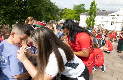 150725 - Wales Women Women’s Rugby World Cup 2025 Kit Launch, National Botanical Gardens of Wales - Maisie Davies with schoolchildren at the launch of the Wales Women’s Rugby World Cup kit at the National Botanical Gardens of Wales