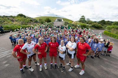 150725 - Wales Women Women’s Rugby World Cup 2025 Kit Launch, National Botanical Gardens of Wales - Wales players, left to right, Molly Reardon, Georgia Evans, Alex Callender, Kate Williams, Keira Bevan, Maisie Davies and Sisilia Tuipulotu with schoolchildren at the launch of the Wales Women’s Rugby World Cup kit at the National Botanical Gardens of Wales