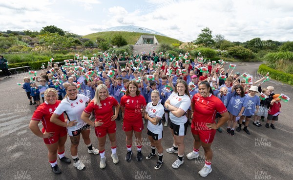 150725 - Wales Women Women’s Rugby World Cup 2025 Kit Launch, National Botanical Gardens of Wales - Wales players, left to right, Molly Reardon, Georgia Evans, Alex Callender, Kate Williams, Keira Bevan, Maisie Davies and Sisilia Tuipulotu with schoolchildren at the launch of the Wales Women’s Rugby World Cup kit at the National Botanical Gardens of Wales