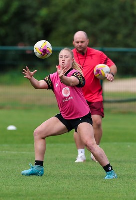 210825 - Wales Women Rugby World Cup Training Session - Seren Lockwood is watched by Sean Lynn, Wales Women head coach, during a Wales training session ahead of their first Women’s Rugby World Cup match against Scotland