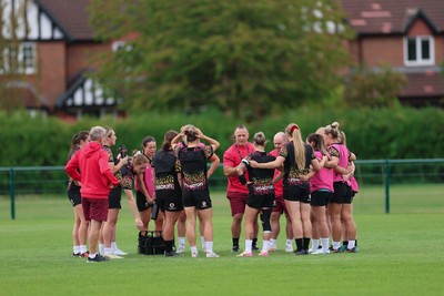 210825 - Wales Women Rugby World Cup Training Session - Shaun Connor, Wales Women attack coach and Sean Lynn, Wales Women head coach speak to the team during a Wales training session ahead of their first Women’s Rugby World Cup match against Scotland