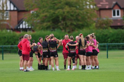 210825 - Wales Women Rugby World Cup Training Session - Shaun Connor, Wales Women attack coach and Sean Lynn, Wales Women head coach speak to the team during a Wales training session ahead of their first Women’s Rugby World Cup match against Scotland