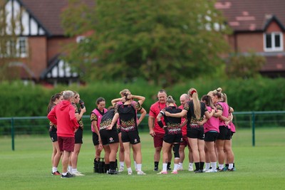 210825 - Wales Women Rugby World Cup Training Session - Shaun Connor, Wales Women attack coach and Sean Lynn, Wales Women head coach speak to the team during a Wales training session ahead of their first Women’s Rugby World Cup match against Scotland
