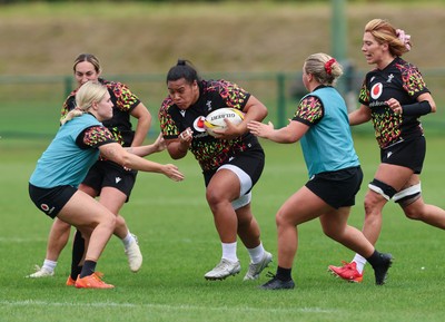 210825 - Wales Women Rugby World Cup Training Session - Sisilia Tuipulotu takes on Alex Callendar and Molly Reardon during a Wales training session ahead of their first Women’s Rugby World Cup match against Scotland