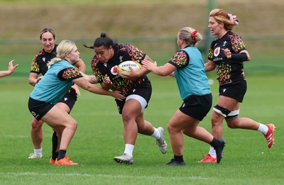 210825 - Wales Women Rugby World Cup Training Session - Sisilia Tuipulotu takes on Alex Callendar and Molly Reardon during a Wales training session ahead of their first Women’s Rugby World Cup match against Scotland