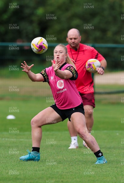 210825 - Wales Women Rugby World Cup Training Session - Seren Lockwood is watched by Sean Lynn, Wales Women head coach, during a Wales training session ahead of their first Women’s Rugby World Cup match against Scotland