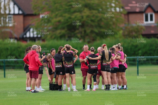 210825 - Wales Women Rugby World Cup Training Session - Shaun Connor, Wales Women attack coach and Sean Lynn, Wales Women head coach speak to the team during a Wales training session ahead of their first Women’s Rugby World Cup match against Scotland
