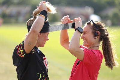 250825 - Wales Women Rugby World Cup Training Session - Kerin Lake is strapped up by Cara Jones, physio, during a Wales training session ahead of their Women’s Rugby World Cup match against Canada