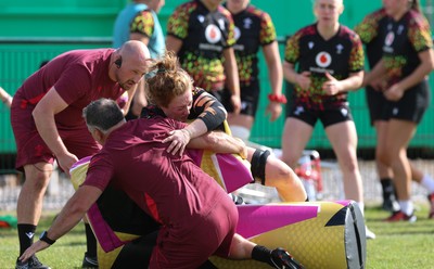 260825 - Wales Women Rugby World Cup Training Session - Shaun Connor, Wales Women attack coach takes a hit from Abbie Fleming during a Wales training session ahead of their Women’s Rugby World Cup match against Canada