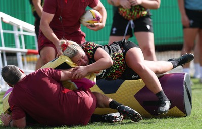 260825 - Wales Women Rugby World Cup Training Session - Shaun Connor, Wales Women attack coach takes a hit from Molly Reardon during a Wales training session ahead of their Women’s Rugby World Cup match against Canada
