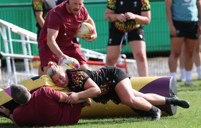 260825 - Wales Women Rugby World Cup Training Session - Shaun Connor, Wales Women attack coach takes a hit from Molly Reardon during a Wales training session ahead of their Women’s Rugby World Cup match against Canada