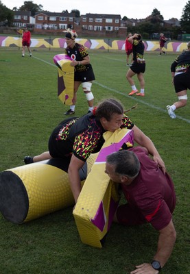 260825 - Wales Women Rugby World Cup Training Session - Shaun Connor, Wales Women attack coach takes a hit from Carys Phillips during a Wales training session ahead of their Women’s Rugby World Cup match against Canada