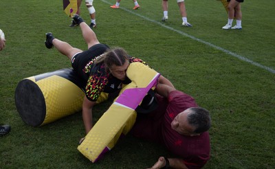 260825 - Wales Women Rugby World Cup Training Session - Shaun Connor, Wales Women attack coach takes a hit from Carys Phillips during a Wales training session ahead of their Women’s Rugby World Cup match against Canada