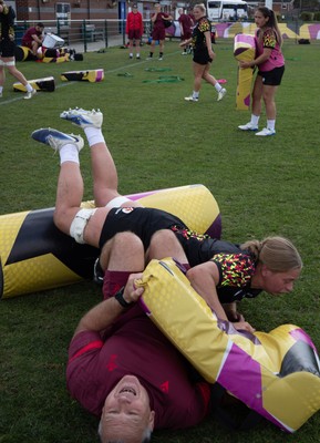 260825 - Wales Women Rugby World Cup Training Session - Shaun Connor, Wales Women attack coach takes a hit from Tilly Vucaj during a Wales training session ahead of their Women’s Rugby World Cup match against Canada