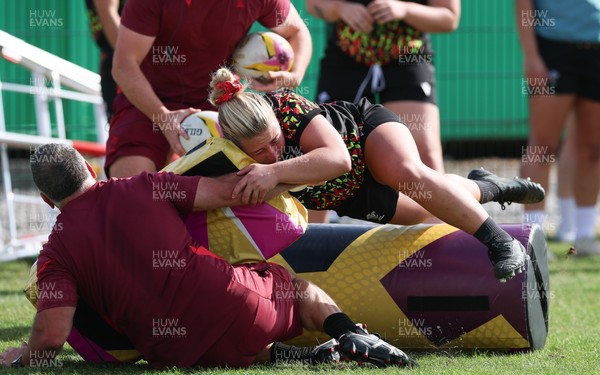 260825 - Wales Women Rugby World Cup Training Session - Shaun Connor, Wales Women attack coach takes a hit from Molly Reardon during a Wales training session ahead of their Women’s Rugby World Cup match against Canada