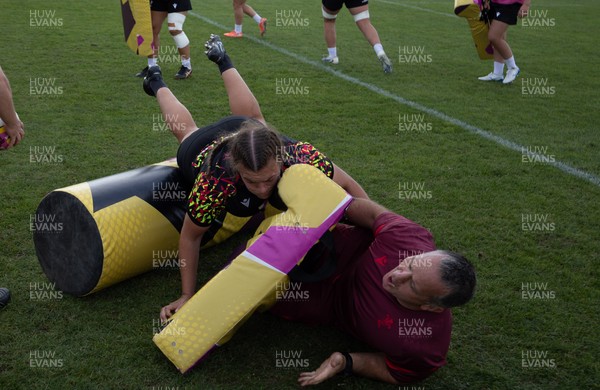 260825 - Wales Women Rugby World Cup Training Session - Shaun Connor, Wales Women attack coach takes a hit from Carys Phillips during a Wales training session ahead of their Women’s Rugby World Cup match against Canada