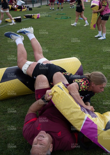 260825 - Wales Women Rugby World Cup Training Session - Shaun Connor, Wales Women attack coach takes a hit from Tilly Vucaj during a Wales training session ahead of their Women’s Rugby World Cup match against Canada