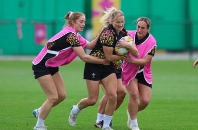 180825 - Wales Women Training Session - Carys Cox gets between Lisa Neumann and Courtney Keight during a Wales Women training session ahead of their first Women’s Rugby World Cup match against Scotland