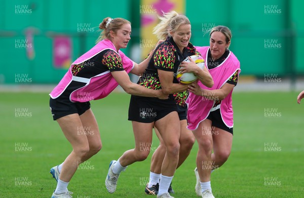 180825 - Wales Women Training Session - Carys Cox gets between Lisa Neumann and Courtney Keight during a Wales Women training session ahead of their first Women’s Rugby World Cup match against Scotland