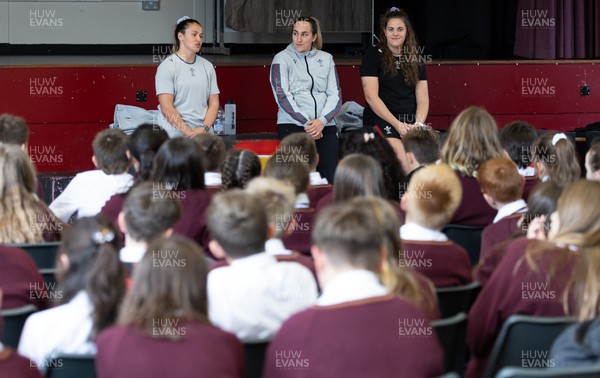 250923 - Wales Women School Visit - Wales Women squad members, left to right, Kayleigh Powell, Courtney Keight and Natalia John speak to pupils at Ysgol Dyffryn Conway, Llanrwst, during a question and answer session at the school