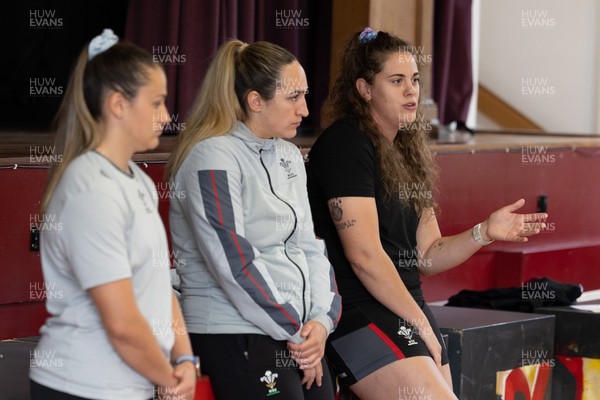 250923 - Wales Women School Visit - Wales Women squad members, left to right, Kayleigh Powell, Courtney Keight and Natalia John speak to pupils at Ysgol Dyffryn Conway, Llanrwst, during a question and answer session at the school