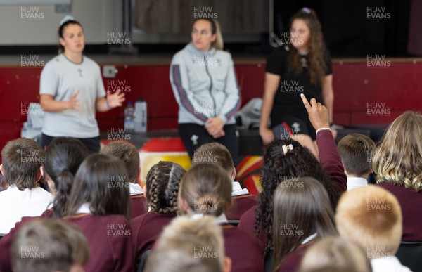 250923 - Wales Women School Visit - Wales Women squad members, left to right, Kayleigh Powell, Courtney Keight and Natalia John speak to pupils at Ysgol Dyffryn Conway, Llanrwst, during a question and answer session at the school