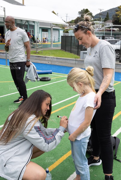 281022 - Wales Women Rugby School Engagement Event at Kamo Primary School - Wales team member Kayleigh Powell signs autographs for Azelia Salmon, aged 7, at Kamo Primary School in Whangarei while meeting the children and taking part in rugby activities
