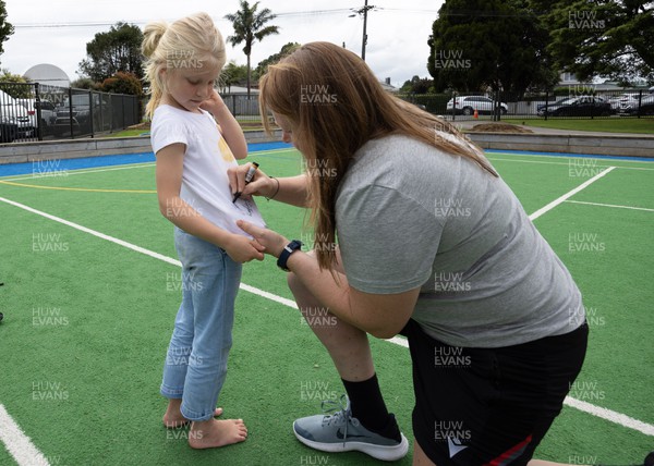 281022 - Wales Women Rugby School Engagement Event at Kamo Primary School - Wales team member Caryl Thomas signs autographs for Azelia Salmon, aged 7, at Kamo Primary School in Whangarei while meeting the children and taking part in rugby activities