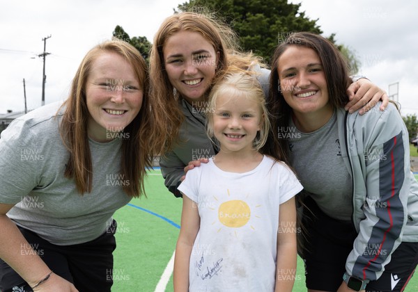 281022 - Wales Women Rugby School Engagement Event at Kamo Primary School - Wales team members Caryl Thomas, Niamh Terry and Kayleigh Powell with Azelia Salmon, aged 7, at Kamo Primary School in Whangarei while meeting the children and taking part in rugby activities
